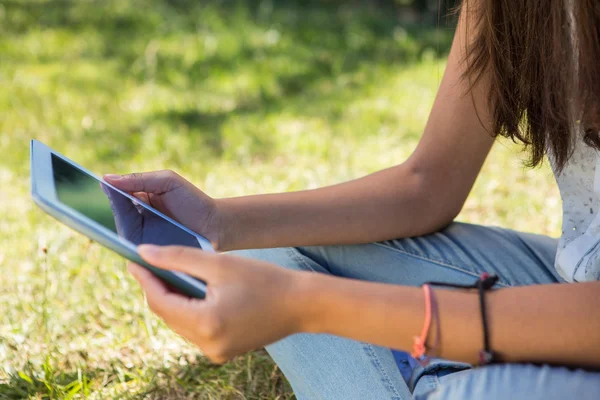 Pretty brunette using tablet in park — Stock Photo, Image