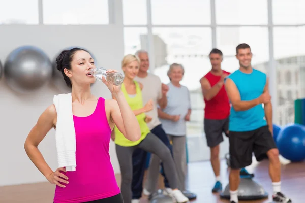 Trött kvinna dricksvatten på gym — Stockfoto