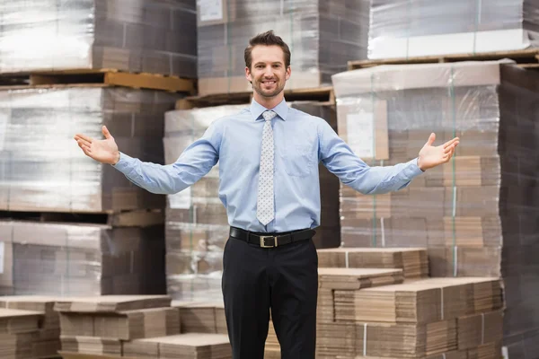 Smiling warehouse manager with hands out — Stock Photo, Image