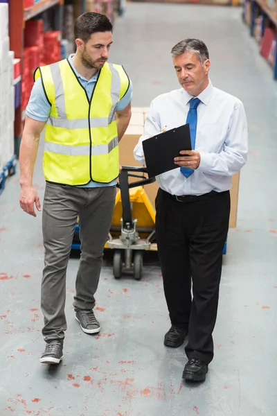 Warehouse worker talking with his manager — Stock Photo, Image