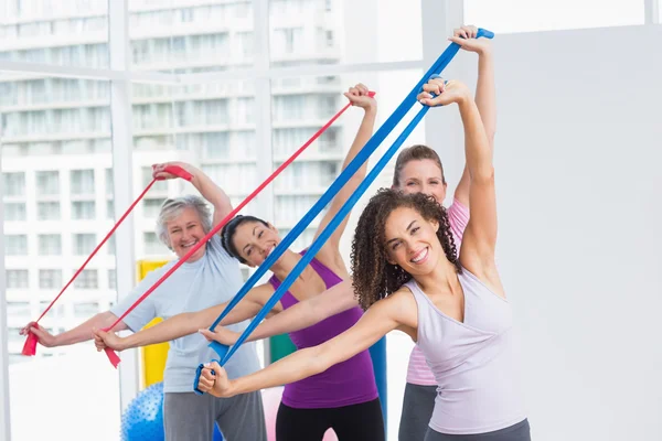 Feliz amigos do sexo feminino exercitando com bandas de resistência — Fotografia de Stock