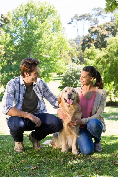 Pareja feliz con su perro en el parque — Foto de Stock