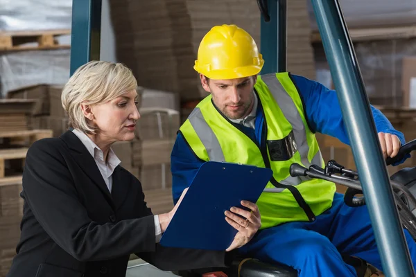Forklift driver talking with manager — Stock Photo, Image