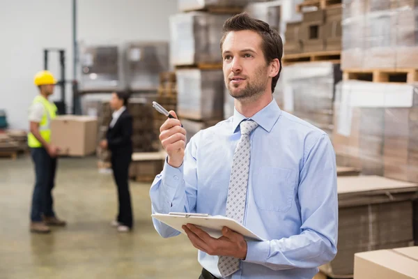 Warehouse manager checking his inventory — Stock Photo, Image