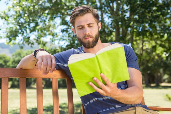 Jeune homme lisant sur le banc du parc — Photo