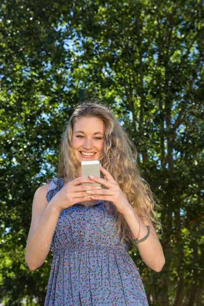 Красивая блондинка по телефону в парке — стоковое фото