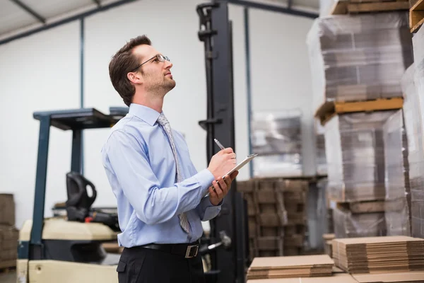 Warehouse manager checking his inventory — Stock Photo, Image