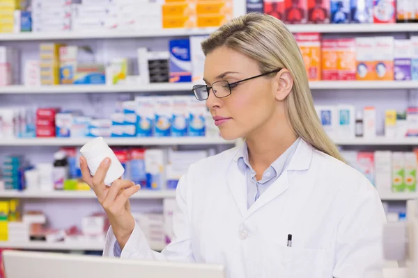 Pharmacist looking at medicine — Stock Photo, Image