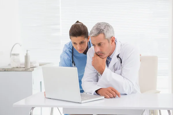 Artsen kijken naar laptop — Stockfoto