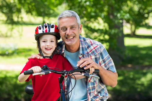 Kleine jongen op fiets met zijn vader — Stockfoto