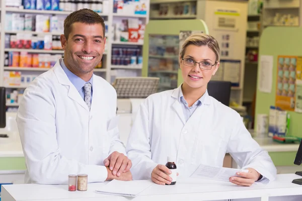 Pharmacists holding a prescription and medicines — Stock Photo, Image
