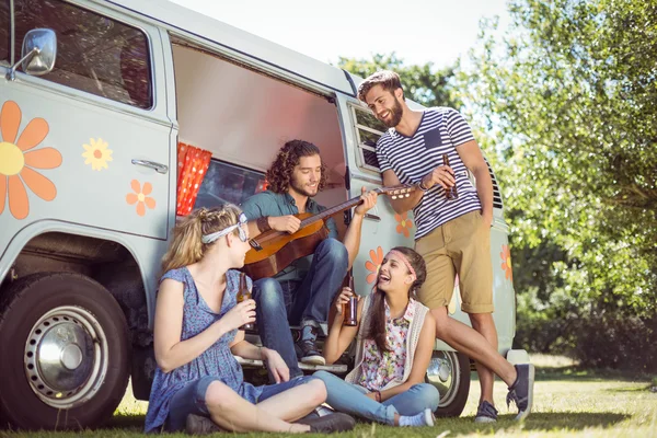 Hipster playing guitar for his friends — Stock Photo, Image