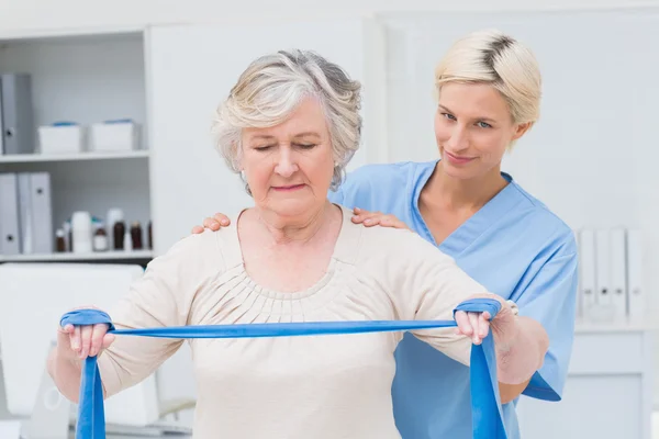 Медсестра ассистирует пожилой женщине в упражнениях — стоковое фото