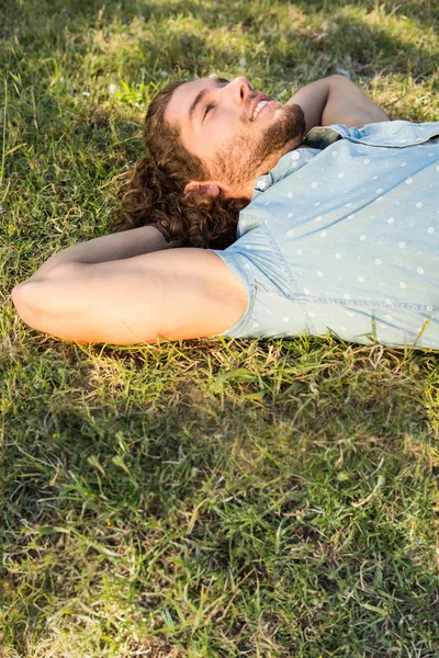 Young man lying down in the park — Stock Photo, Image