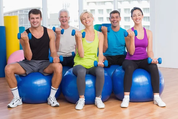 Persone che lavorano su palle di esercizio a lezione di ginnastica — Foto Stock