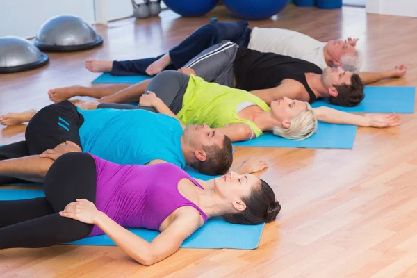 Pessoas esticando as pernas no estúdio de fitness — Fotografia de Stock