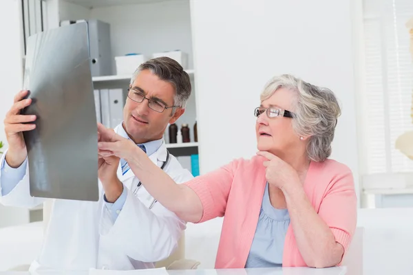 Doctor explicando rayos X al paciente mayor — Foto de Stock