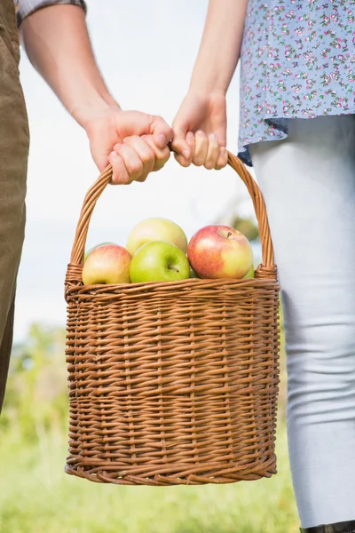 Casal segurando cesta de maçãs — Fotografia de Stock