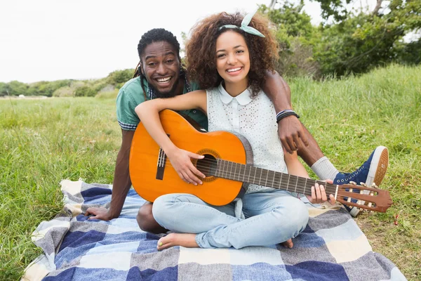 Пара на пикнике, играющая на гитаре — стоковое фото