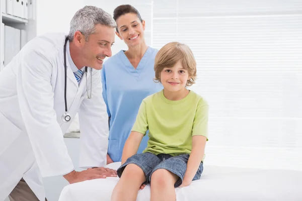 Chłopiec uśmiecha się do kamery z lekarzy — Zdjęcie stockowe
