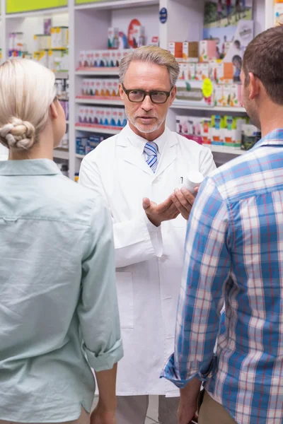 Farmacêutico explicando pílulas para o paciente — Fotografia de Stock