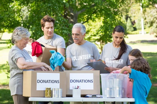 Volunteer family separating donations stuffs — Stock Photo, Image