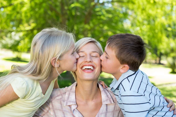 Zus en broer kussen hun moeder — Stockfoto