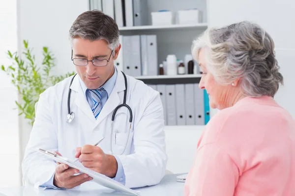 Médico explicando recetas a la mujer — Foto de Stock