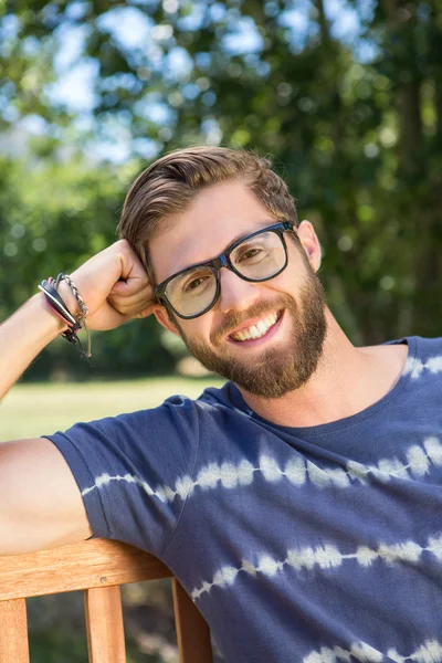 Schöner Hipster sitzt auf Parkbank — Stockfoto