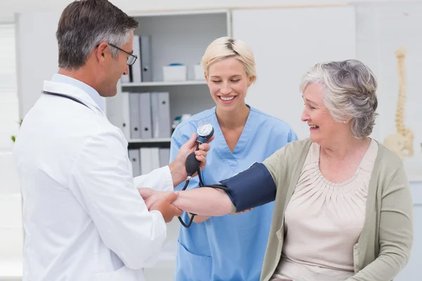 Doctor checking patients blood pressure — Stock Photo, Image