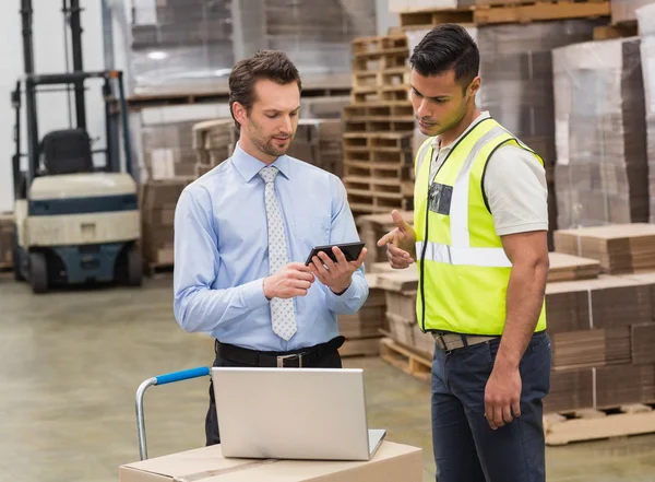 Magazijnmedewerker praten met zijn manager — Stockfoto