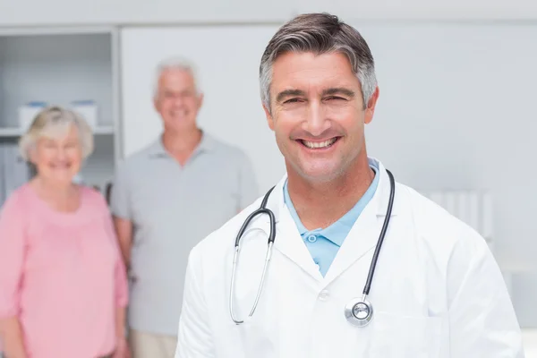 Arzt lächelt mit Senioren-Paar — Stockfoto