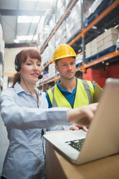 Smiling businesswoman wearing headset using laptop — Stock Photo, Image