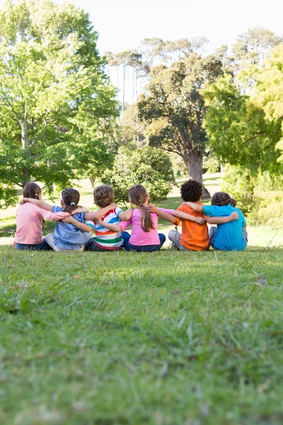 School children sitting on grass — Stock Photo, Image