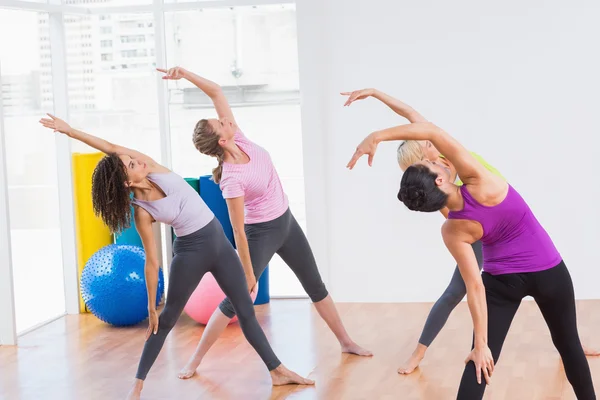 Treinador e amigas fazendo exercício de alongamento — Fotografia de Stock