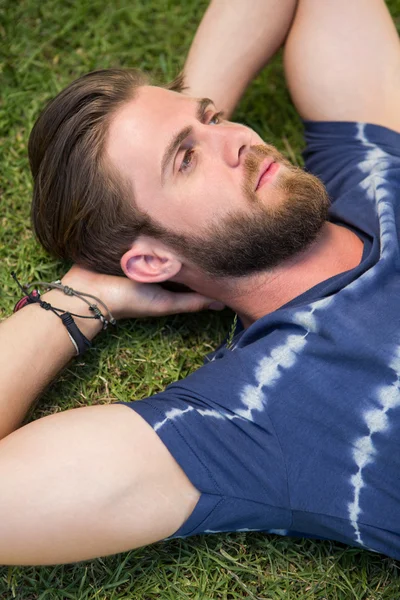 Handsome hipster lying on grass — Stock Photo, Image