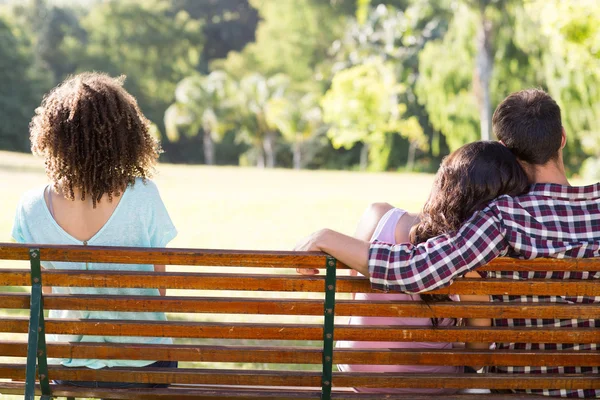Einsame Frau sitzt mit Paar im Park — Stockfoto
