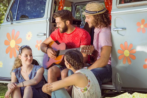 Hipster friends sitting by camper van — Stock Photo, Image
