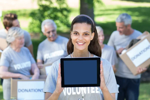 Freiwillige Brünette zeigt Tablet-PC-Bildschirm — Stockfoto