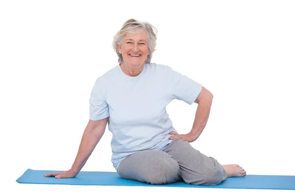 Mulher sênior sorrindo no tapete de exercício — Fotografia de Stock