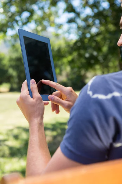 タブレットを使用して公園のベンチで若い男 — ストック写真