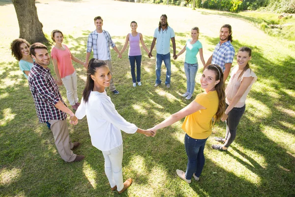 Happy friends in the park holding hands — Stock Photo, Image