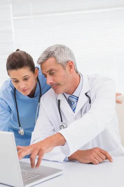 Los médicos mirando a la computadora portátil — Foto de Stock