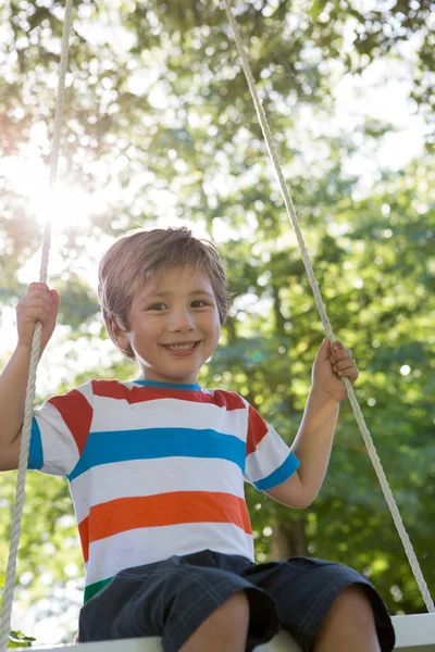 Liten pojke på gunga i parken — Stockfoto