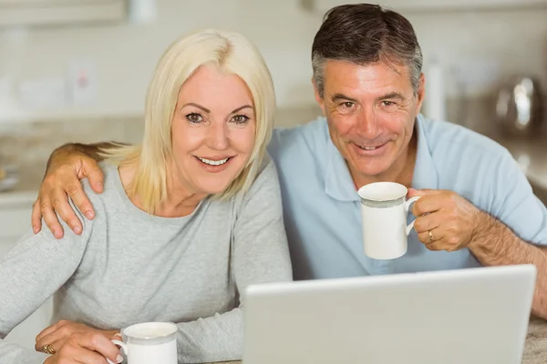 Pareja madura feliz usando el ordenador portátil —  Fotos de Stock