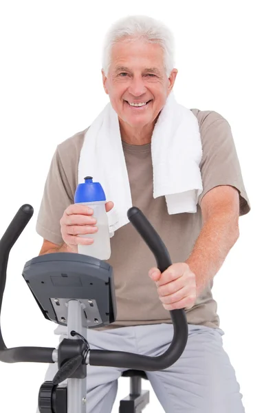 Homem sênior em bicicleta de exercício — Fotografia de Stock