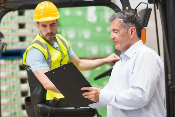 Forklift driver talking with his manager — Stock Photo, Image