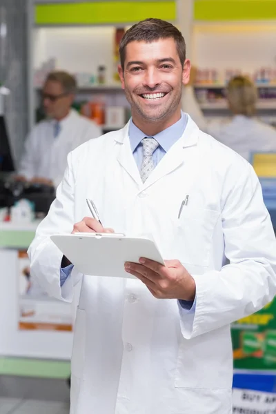 Feliz farmacêutico escrevendo na área de transferência — Fotografia de Stock