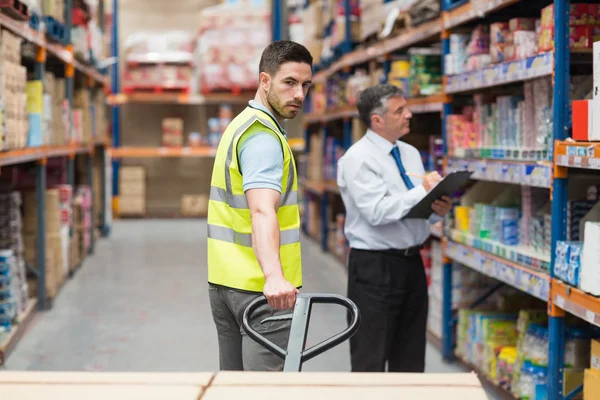 Warehouse worker talking with his manager — Stock Photo, Image