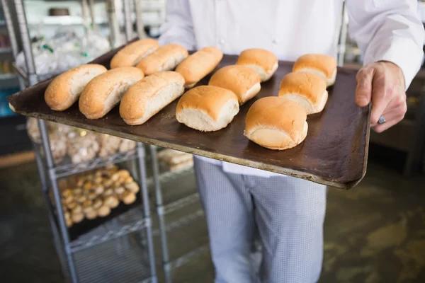 Baker holding tray with bread — Stock Photo, Image